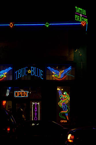 Tatoo parlor with neon signs at night